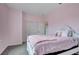 Spacious bedroom with pink walls, a queen bed, and double door closet at 1551 Gateway Ln, Kissimmee, FL 34746