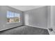 Spacious bedroom with gray walls, gray carpet, and a window with natural light at 1551 Gateway Ln, Kissimmee, FL 34746