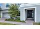 Modern front door entrance with gray stucco and landscaping at 1551 Gateway Ln, Kissimmee, FL 34746