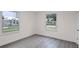 Simple bedroom with gray vinyl flooring and two windows at 1703 E Fern Rd, Lakeland, FL 33801