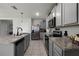 Modern kitchen with gray cabinets, granite countertops and stainless steel appliances at 229 Gina Ln, Davenport, FL 33837