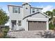 Two-story house with gray siding, brown garage door, and a paved driveway at 266 Southfield St, Kissimmee, FL 34747