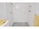 Large shower with marble-style tile and grey hexagon floor at 2661 Ames Haven Rd, Kissimmee, FL 34744