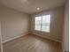 Cozy bedroom with wood floors and a large window letting in natural light at 2753 Redblush Ter, St Cloud, FL 34772