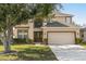 Two-story house with tan siding, brown accents, and a two-car garage at 2760 Curpin Ln, Orlando, FL 32825