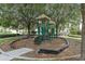 Community playground with playset, slide, and climbing structures, surrounded by trees at 2821 Almaton Loop # 303, Kissimmee, FL 34747