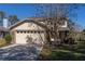 Two-story house with beige exterior, brick accents, and a two-car garage at 3511 Exeter Ct, Orlando, FL 32812