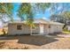 Newly renovated gray brick home with a white door and wood posts at 355 E Hoffman St, Lake Alfred, FL 33850