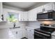 Modern kitchen with white cabinets, stainless steel appliances, and quartz countertops at 355 E Hoffman St, Lake Alfred, FL 33850