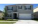 Two-story house with gray siding, white garage door, and landscaping at 3852 Rory Pond Ct, Lakeland, FL 33811