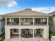 Two-story home with balcony, columns, and a large backyard at 395 Muirfield Loop, Reunion, FL 34747