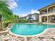 Inviting pool with water features, surrounded by a brick patio and lush landscaping at 395 Muirfield Loop, Reunion, FL 34747