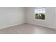 An empty bedroom with light wood-look flooring with white walls and a single window at 445 N Andrea Cir, Haines City, FL 33844