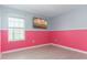 Bright bedroom with pink walls, window, and wood-look floors at 445 N Andrea Cir, Haines City, FL 33844