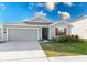 Gray house with red shutters, two-car garage, and landscaped lawn at 445 N Andrea Cir, Haines City, FL 33844