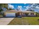 Ranch-style home with a white garage door and well-manicured lawn at 501 S Lacy Cir, Deltona, FL 32725