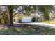 House with a large tree in front and a long driveway at 501 S Lacy Cir, Deltona, FL 32725