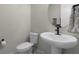 Modern powder room with pedestal sink, toilet, and updated fixtures at 5157 Citrus Leaf Blvd, Winter Garden, FL 34787