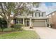 Two-story house with a gray exterior, a brick driveway, and landscaping at 528 Legacy Park Dr, Casselberry, FL 32707