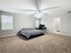 Large bedroom with carpeted floor, ceiling fan, and striped bedding at 5381 Maddie Dr, Haines City, FL 33844