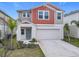 Two-story house with gray and burnt orange siding, two-car garage, and landscaping at 5381 Maddie Dr, Haines City, FL 33844