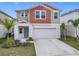 Two-story house with gray and burnt orange siding, two-car garage, and landscaping at 5381 Maddie Dr, Haines City, FL 33844