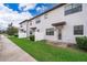 Townhouse exterior featuring a private patio and well-manicured lawn at 8545 Couples St, Davenport, FL 33896