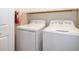 Laundry room with washer and dryer, shelving, and ironing board at 8545 Couples St, Davenport, FL 33896