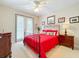 Guest bedroom with red bedding and private balcony at 910 Lotus Vista Dr # 201, Altamonte Springs, FL 32714