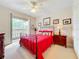 Guest bedroom with red bedding and private balcony access at 910 Lotus Vista Dr # 201, Altamonte Springs, FL 32714