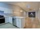 Modern kitchen with white shaker cabinets, stainless steel appliances, and an island at 10738 Se 50Th Ave, Belleview, FL 34420