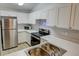Modern kitchen with white cabinets, stainless steel appliances, and light flooring at 10738 Se 50Th Ave, Belleview, FL 34420