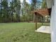 Lush green backyard with a pergola, perfect for outdoor entertaining and relaxing in a natural setting at 13188 Sw Sw 65Th Cir, Ocala, FL 34473