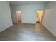 Spacious bedroom with wood-look flooring leading to a walk-in closet and bathroom, perfect for relaxation at 13188 Sw Sw 65Th Cir, Ocala, FL 34473