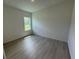 Clean, bright bedroom with wood-look flooring and a large window at 13188 Sw Sw 65Th Cir, Ocala, FL 34473