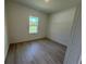 Inviting bedroom with wood-look flooring and a serene window view at 13188 Sw Sw 65Th Cir, Ocala, FL 34473