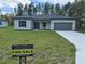 Inviting single-story home with a 'For Sale' sign on a lush green lawn at 13188 Sw Sw 65Th Cir, Ocala, FL 34473