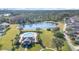 Community pool and clubhouse with a pond and lush green space at 14457 Jamaica Dogwood Dr, Orlando, FL 32828