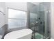 Modern bathroom featuring a soaking tub next to a window and a glass-enclosed shower at 14457 Jamaica Dogwood Dr, Orlando, FL 32828