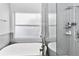 Modern bathroom features sleek soaking tub and glass-enclosed shower at 14457 Jamaica Dogwood Dr, Orlando, FL 32828
