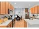 Spacious kitchen with stainless steel appliances, wood cabinets, and a view into the dining area at 14457 Jamaica Dogwood Dr, Orlando, FL 32828