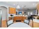 Open concept kitchen offering wooden cabinets, breakfast bar, stainless steel appliances, and a dining area at 14457 Jamaica Dogwood Dr, Orlando, FL 32828