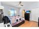 Bright main bedroom featuring a large bed, hardwood floors, and window with natural light at 14457 Jamaica Dogwood Dr, Orlando, FL 32828