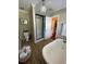 Clean bathroom with soaking tub, walk in shower, and hardwood floors at 1817 Kalurna Ct, Orlando, FL 32806