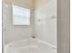 Bathroom featuring a corner bathtub and window at 193 Aurelia Ct, Kissimmee, FL 34758