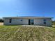 Backyard exterior featuring a large sliding glass door and a lush, grassy lawn at 238 Locust Rd, Ocala, FL 34472