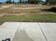 A backyard featuring a concrete patio and a large, empty lot at 238 Locust Rd, Ocala, FL 34472