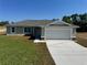 Charming single-story home with a two-car garage and a well-maintained front lawn on a sunny day at 238 Locust Rd, Ocala, FL 34472