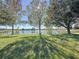 Spacious backyard with a lake view, lush grass, and large trees at 250 Bayou Bend Rd, Groveland, FL 34736