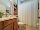 Clean bathroom with a shower/tub combo, wood vanity, and white waffle weave shower curtain at 250 Bayou Bend Rd, Groveland, FL 34736